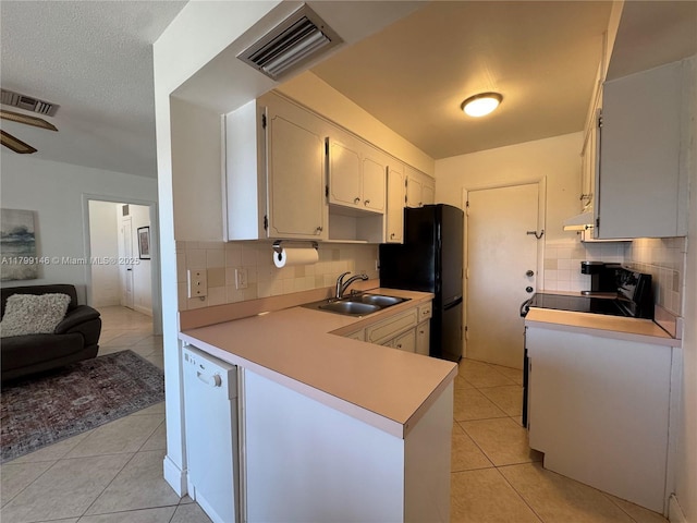 kitchen featuring a sink, light tile patterned floors, backsplash, and black appliances