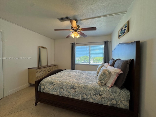 bedroom with light tile patterned floors, a ceiling fan, a textured ceiling, and baseboards