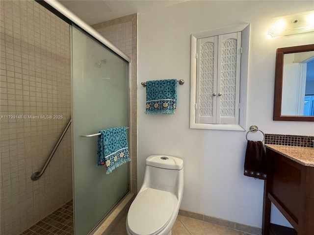 bathroom with a shower stall, tile patterned floors, toilet, and vanity
