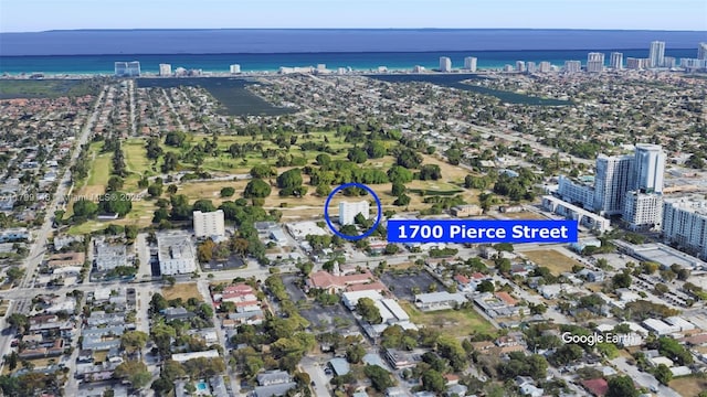 aerial view of property and surrounding area with nearby urban area and a large body of water