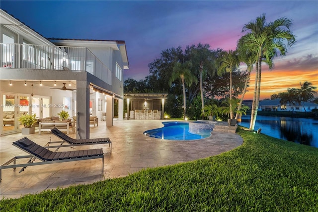 20230 NW 7th St, Pembroke Pines, FL 33029 - pool at dusk with a patio, a ceiling fan, a pool with connected hot tub, a water view, and a lawn