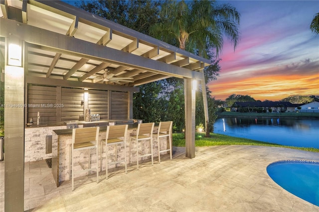 20230 NW 7th St, Pembroke Pines, FL 33029 - patio terrace at dusk with exterior bar, a patio, a ceiling fan, a water view, and an outdoor pool