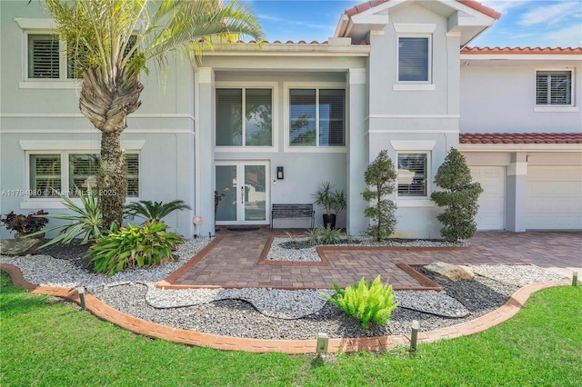 20230 NW 7th St, Pembroke Pines, FL 33029 - property entrance featuring a tiled roof, french doors, stucco siding, and an attached garage