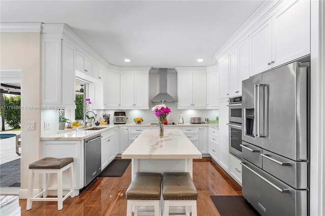 20230 NW 7th St, Pembroke Pines, FL 33029 - kitchen featuring appliances with stainless steel finishes, wall chimney exhaust hood, a sink, white cabinetry, and recessed lighting