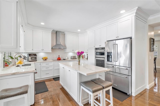 20230 NW 7th St, Pembroke Pines, FL 33029 - kitchen with appliances with stainless steel finishes, wall chimney range hood, white cabinets, light wood-type flooring, and recessed lighting