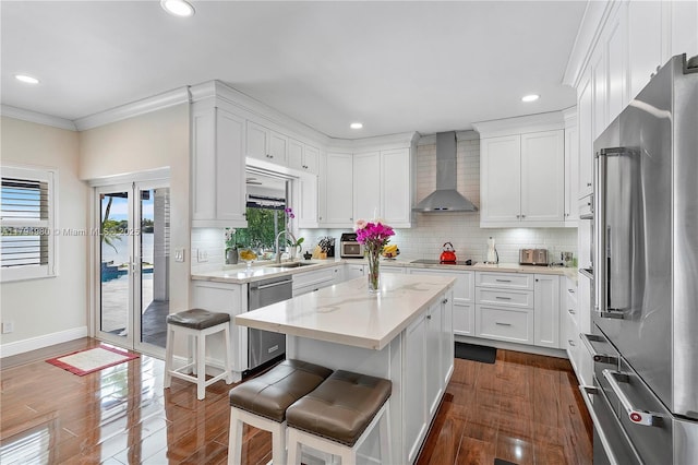 20230 NW 7th St, Pembroke Pines, FL 33029 - kitchen featuring appliances with stainless steel finishes, wall chimney exhaust hood, a sink, a kitchen island, and white cabinetry