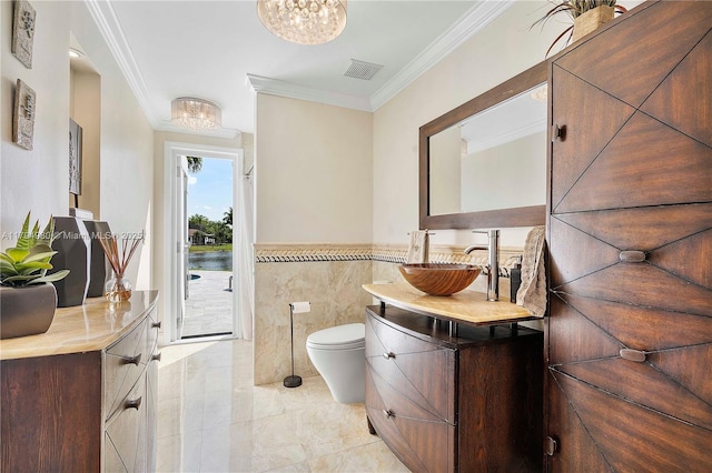 20230 NW 7th St, Pembroke Pines, FL 33029 - bathroom featuring a chandelier, vanity, crown molding, tile walls, and a wainscoted wall