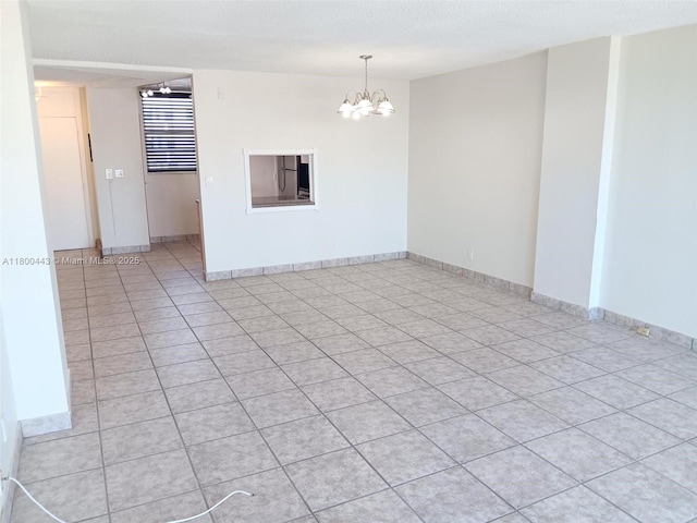 3703 NE 166th St Unit 704, North Miami Beach, FL 33160 - unfurnished room with a chandelier, light tile patterned floors, and baseboards
