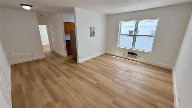 7334 Harding Ave Unit 3, Miami Beach, FL 33141 - unfurnished room featuring electric panel, light wood-style flooring, heating unit, and baseboards