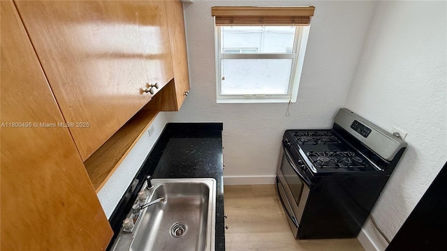 7334 Harding Ave Unit 3, Miami Beach, FL 33141 - kitchen featuring stainless steel gas stove, a textured wall, baseboards, and wood finished floors