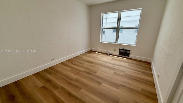 7334 Harding Ave Unit 3, Miami Beach, FL 33141 - unfurnished room with baseboards, light wood finished floors, heating unit, and a textured wall
