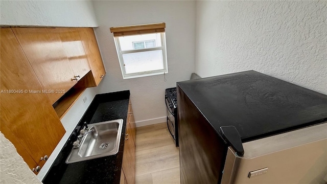 7334 Harding Ave Unit 3, Miami Beach, FL 33141 - kitchen with a sink, baseboards, light wood-style floors, and a textured wall