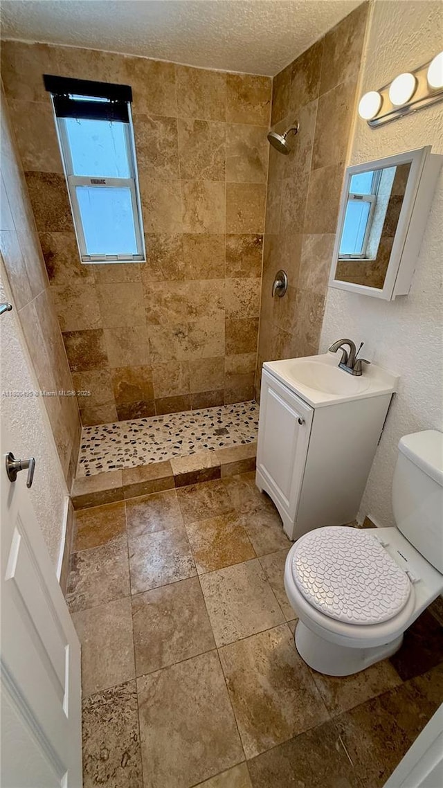 7334 Harding Ave Unit 3, Miami Beach, FL 33141 - bathroom with toilet, tiled shower, vanity, a textured ceiling, and stone finish flooring