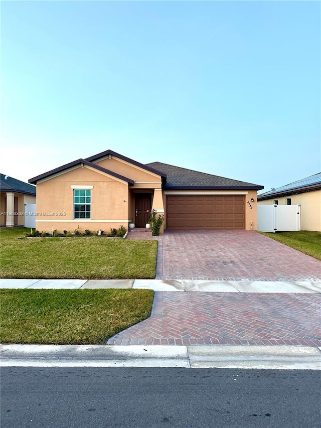 view of front of home featuring stucco siding, decorative driveway, and an attached garage