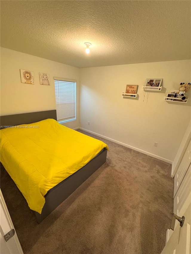 carpeted bedroom with a textured ceiling and baseboards