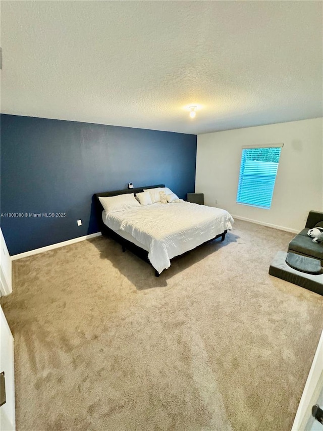 bedroom with carpet, a textured ceiling, and baseboards