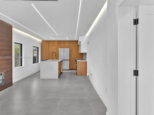 4921 NW 6th Ave, Miami, FL 33127 - kitchen with brown cabinets, modern cabinets, light countertops, a sink, and baseboards