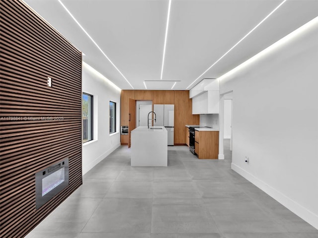 4921 NW 6th Ave, Miami, FL 33127 - kitchen featuring light countertops, baseboards, a center island with sink, modern cabinets, and a sink
