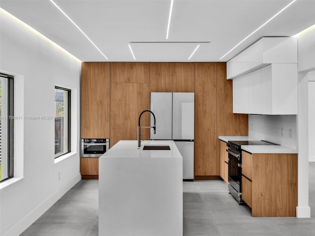 4921 NW 6th Ave, Miami, FL 33127 - kitchen featuring modern cabinets, appliances with stainless steel finishes, light countertops, a kitchen island with sink, and a sink