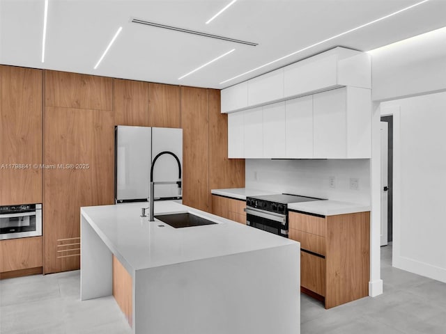 4921 NW 6th Ave, Miami, FL 33127 - kitchen with freestanding refrigerator, black range with electric cooktop, modern cabinets, stainless steel oven, and a sink