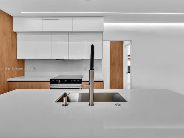 4921 NW 6th Ave, Miami, FL 33127 - kitchen with electric stove, modern cabinets, a sink, light countertops, and white cabinets