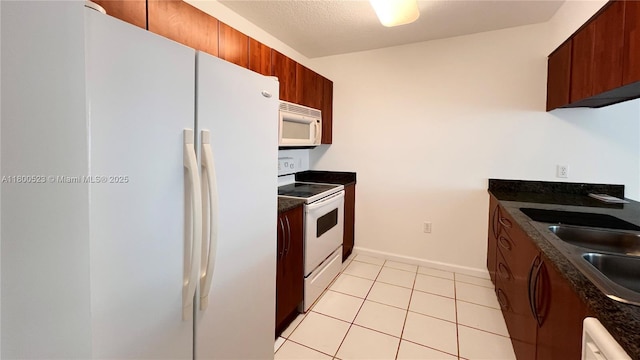 1200 Brickell Bay Dr Unit 2814, Miami, FL 33131 - kitchen featuring white appliances, dark countertops, a sink, light tile patterned flooring, and baseboards