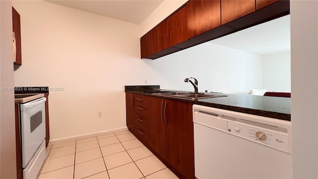 1200 Brickell Bay Dr Unit 2814, Miami, FL 33131 - kitchen with white appliances, a sink, dark countertops, light tile patterned floors, and baseboards