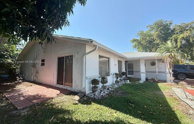 4909 Bayberry Ln, Tamarac, FL 33319 - view of property exterior featuring stucco siding, a yard, and a patio