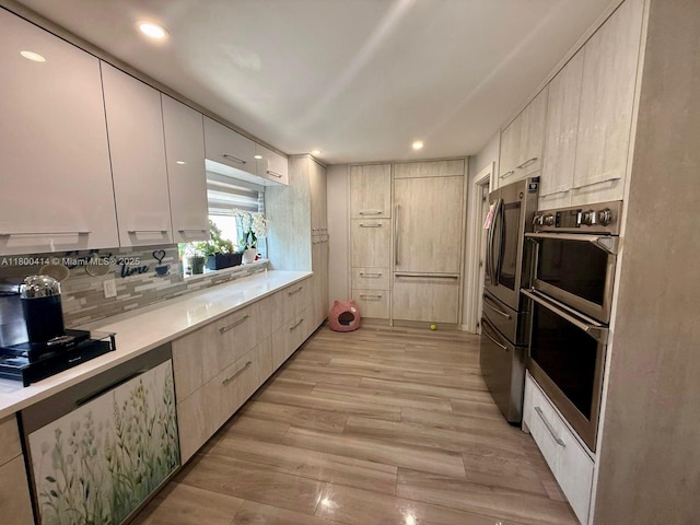 4909 Bayberry Ln, Tamarac, FL 33319 - kitchen with appliances with stainless steel finishes, modern cabinets, light countertops, light wood-style floors, and tasteful backsplash