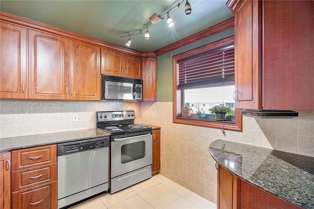 4800 Hillcrest Ln Unit 503, Hollywood, FL 33021 - kitchen featuring appliances with stainless steel finishes, dark stone countertops, light tile patterned floors, brown cabinets, and tile walls