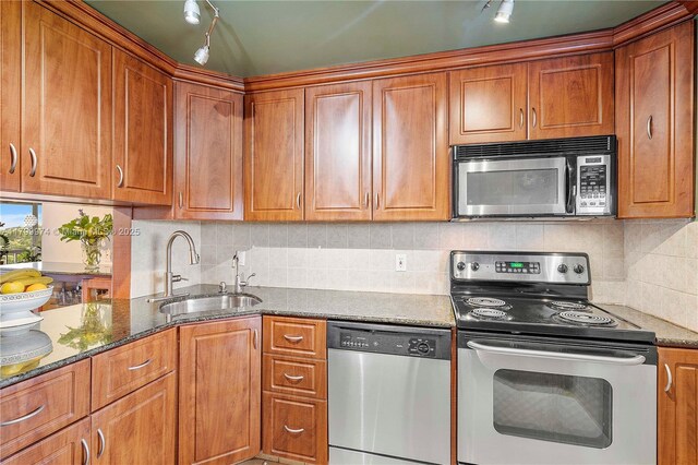 4800 Hillcrest Ln Unit 503, Hollywood, FL 33021 - kitchen with appliances with stainless steel finishes, brown cabinetry, dark stone counters, and decorative backsplash