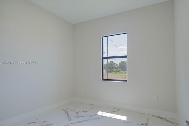 spare room with marble look tiles and baseboards