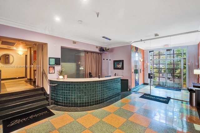 reception area featuring wet bar, crown molding, and recessed lighting