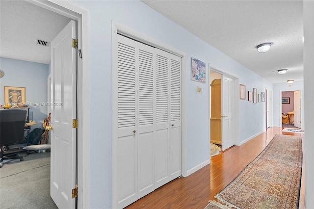 9905 SW 131st St, Miami, FL 33176 - corridor featuring a textured ceiling, wood finished floors, and an office area
