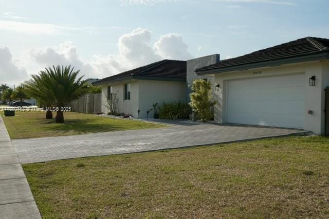 20600 SW 316th St, Homestead, FL 33030 - view of property exterior with decorative driveway, a garage, and stucco siding