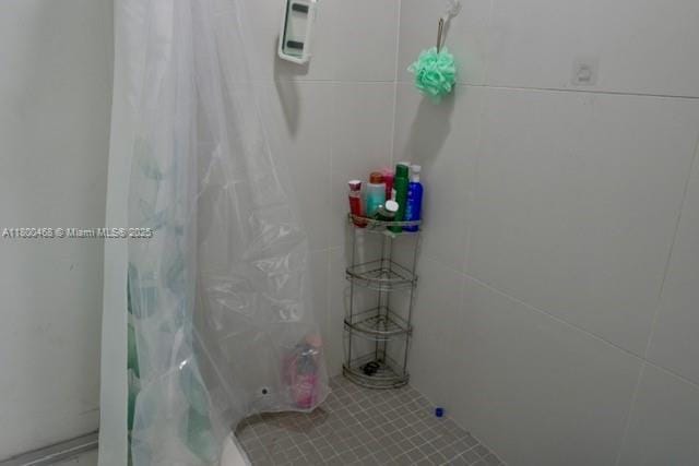 20600 SW 316th St, Homestead, FL 33030 - full bathroom with a shower with shower curtain, tile walls, and tile patterned floors