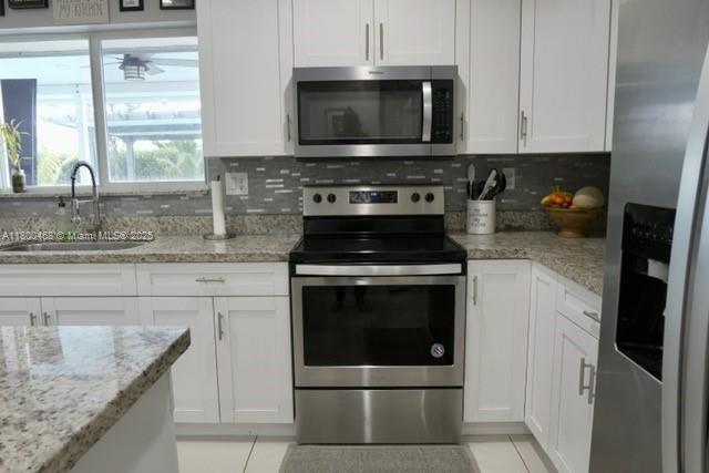 20600 SW 316th St, Homestead, FL 33030 - kitchen featuring stainless steel appliances, a sink, and white cabinets