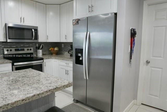 20600 SW 316th St, Homestead, FL 33030 - kitchen with appliances with stainless steel finishes, white cabinetry, decorative backsplash, and light tile patterned floors