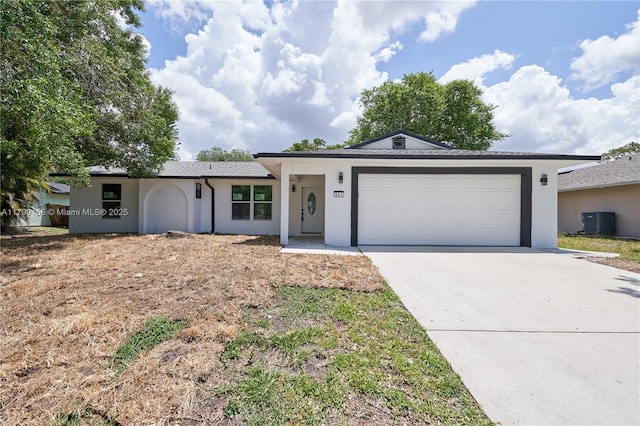 ranch-style home featuring central AC unit, stucco siding, and concrete driveway