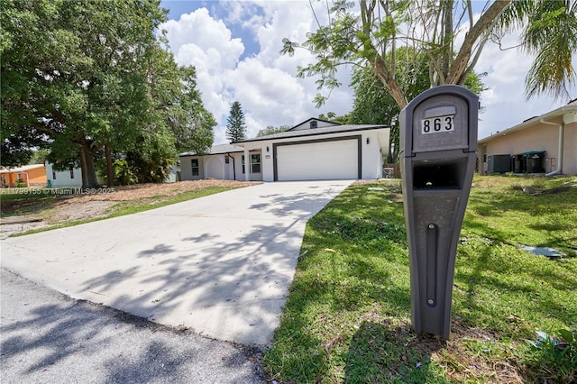 view of front facade featuring a garage, concrete driveway, stucco siding, and a front lawn
