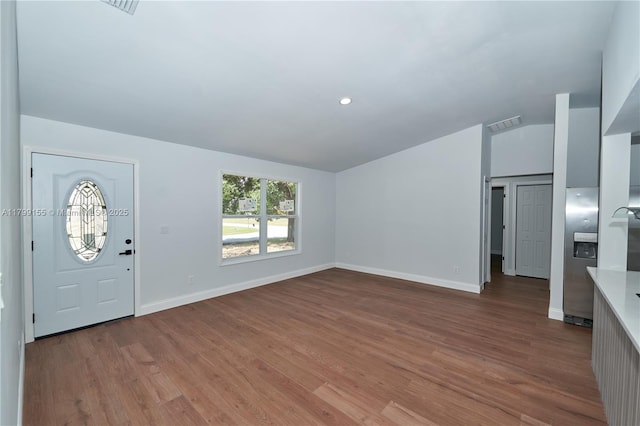 foyer entrance featuring lofted ceiling, wood finished floors, and baseboards