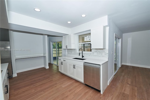 kitchen with dishwasher, a sink, white cabinets, light wood-style floors, and recessed lighting