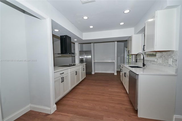 kitchen featuring a sink, stainless steel appliances, exhaust hood, light countertops, and baseboards