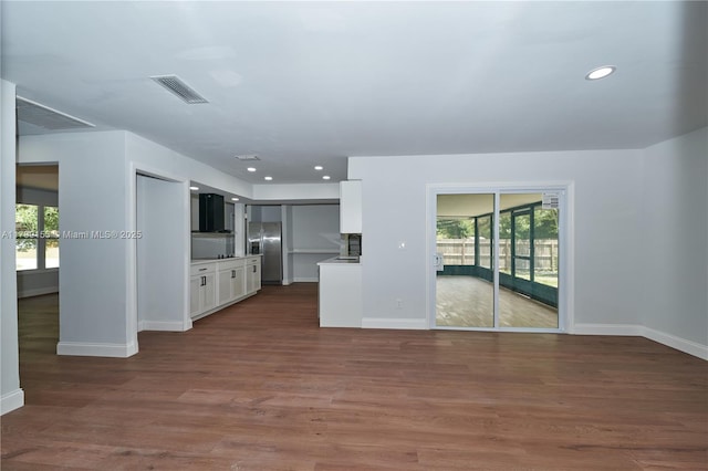 unfurnished living room with baseboards, dark wood-style floors, and recessed lighting