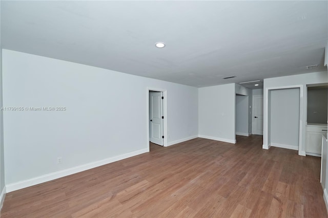 unfurnished room with light wood-style flooring, baseboards, and recessed lighting
