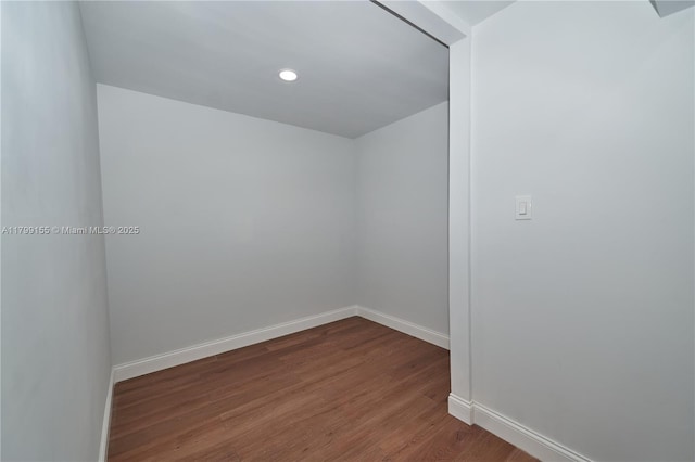 empty room featuring wood finished floors, baseboards, and recessed lighting