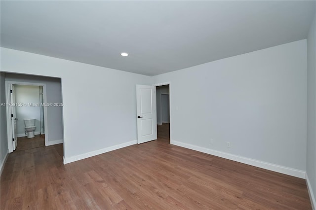 unfurnished bedroom with baseboards, wood finished floors, and recessed lighting