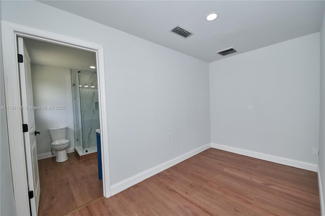 spare room featuring wood finished floors, baseboards, and recessed lighting