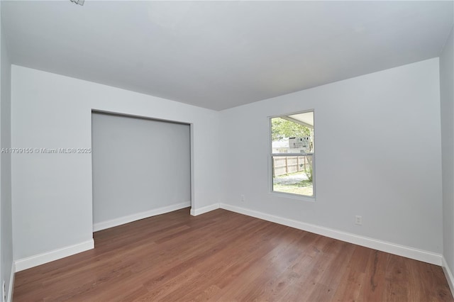 empty room featuring baseboards and wood finished floors
