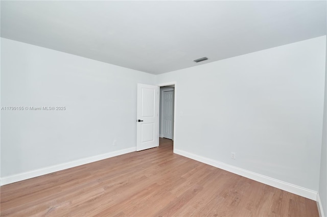 unfurnished room featuring baseboards and light wood-style flooring